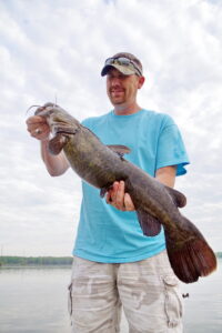The author’s son, Josh Sutton, lands a nice Lake Conway flathead that is typical in size for this cover-filled central Arkansas impoundment. (Photo: Keith Sutton)