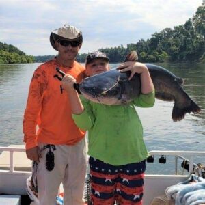 As Nathan and Joshua increased their catfishing skills, bigger fish came to the boat. They are shown here with a nice trophy blue cat. (Submitted photo)