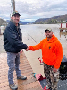 Ryan Bosserman with the West Virginia DNR is shown here congratulating Carver. Bosserman weighed the fish and confirmed that it was the new WV state record at 61.28 pounds. 