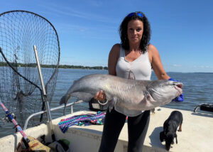 Samantha Gay’s first trophy blue fishing adventure resulted in 6 citation blue cats. She is shown here with her first one. 
