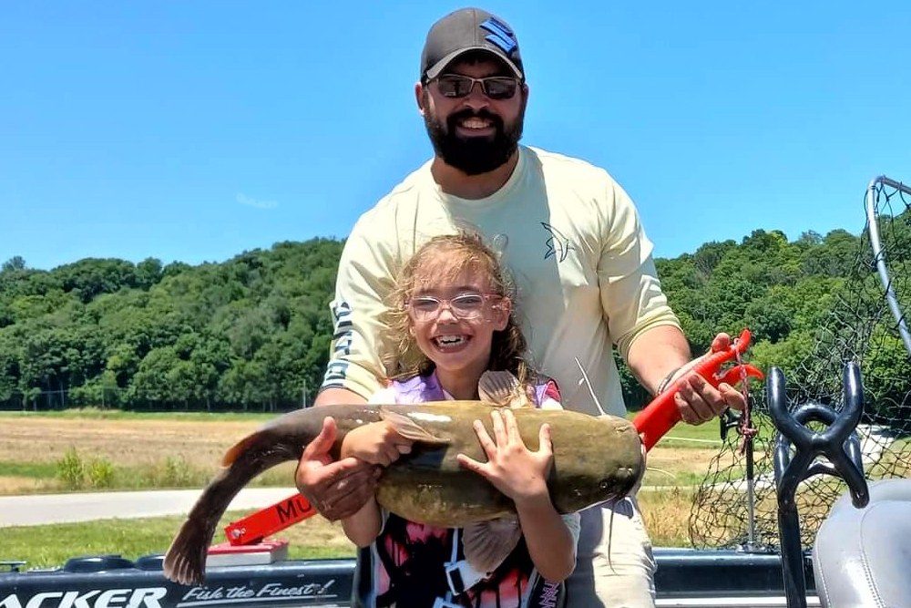 father and daughter holding big catfish