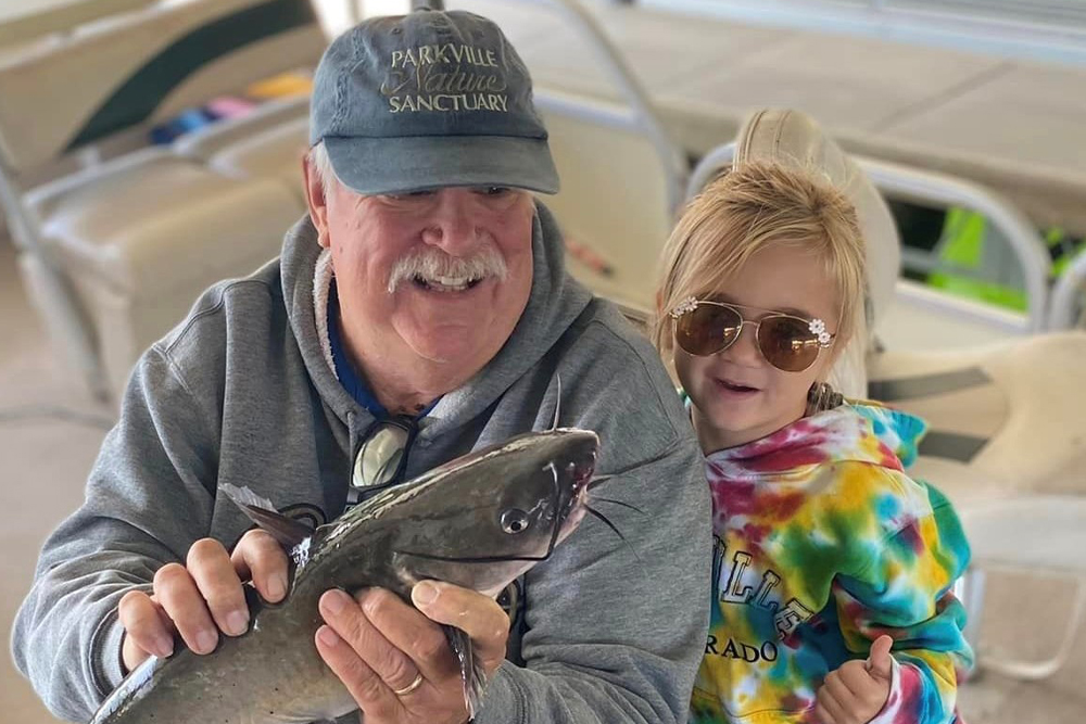 Little Avery didn’t want to hold the channel catfish she caught, but she wanted to be in the picture with grandpa. (Jenny Schiltz Photo)| Cattin' with Grandkids