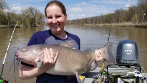 The author’s wife Lisa holding a prespawn Red River channel cat. Look at the distinct current seam that is formed right behind the boat. This seam shows the breakline where the main current meets the OFF current seam to the outside of the bank.