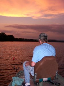 Doug Williams in his “happy place”- watching catfish jugs drift down the Tennessee River beneath a brilliant orange sunset.