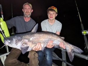 A peaceful evening interrupted by frantic action on Taylor's boat kept Mike and Ben Robertson busy with big blues and flatheads sometimes hooked two at a time. 