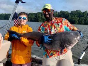 Capt. John emphasizes the necessity of fresh bait to successfully catch trophy tidal cats like the one held here by a young angler. 