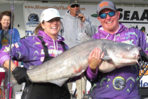 photo of couple holding a catfish