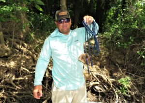 Joey Pounders is shown with one of his weighed throw lines which he will toss over a limb to secure the boat. He will use as many as needed to give him the proper boat position to fish his targeted hole. 