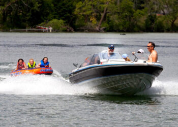 boat pulling kids on raft