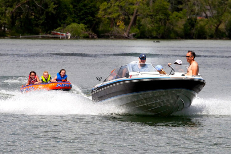 boat pulling kids on raft