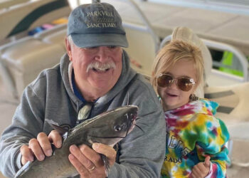 Little Avery didn’t want to hold the channel catfish she caught, but she wanted to be in the picture with grandpa. (Jenny Schiltz Photo)| Cattin' with Grandkids