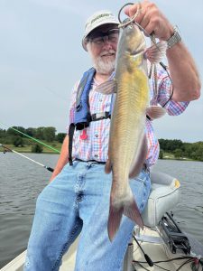 Doug Piper admires one of the channel catfish he caught on chunks of chicken breast marinated in cherry Kool-Aid. 