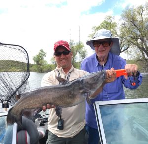 Tyler Brown (left) guides customers to big channel cats on Merritt Reservoir in Nebraska.