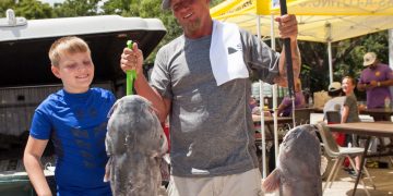 Morgan City Oilfield Fishing Rodeo angler Jacob Aucoin (right) shows off two blue catfish during the 2025 event in Morgan City. His fish on the left weighed 37.78 pounds, good enough for third place during the event.